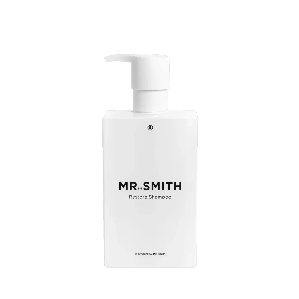 Witte pompflacon van Mr. Smith Restore Shampoo van 275 ml tegen een zwarte achtergrond.