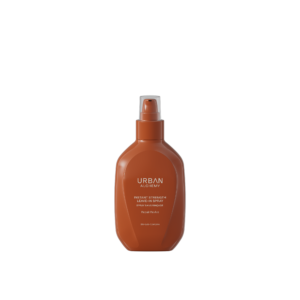 Bruine fles Urban Alchemy Instant Strength Leave-In Spray met pompverstuiver, tegen een zwarte achtergrond.