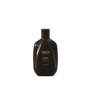 Zwarte fles Urban Alchemy Smooth Satin shampoo met minimalistisch ontwerp op een zwarte achtergrond.