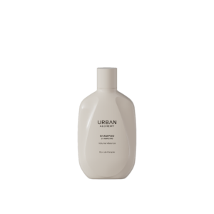 Crèmekleurige fles Urban Alchemy Volume Vibrance shampoo met minimalistisch zwart opschrift.